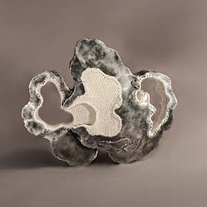 Close to Balance by Amanda Langer  Image: Two organic steel forms lean against each other. Knitted wool fiber connects the piece, creating a shared pocked. Two large organic holes on either end of piece lined with knitted wool yarn.