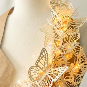 Migration by Jen Haefeli  Image: Migration
Mixed Media Sculpture
Upcycled Shipping Paper & Children's Drawing Paper, Adhesive, Miniature Lights, Displayed on a female mannequin frame. 
2025
