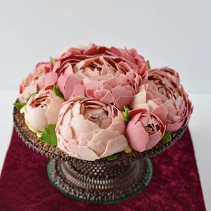 Chocolate artwork "Peony flowers" by Gerhard Petzl  Image: Peony flowers arrangement on baroque stand, 100% chocolate, on red velvet board