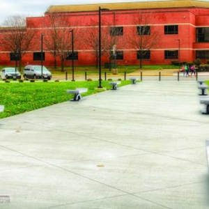 Syncopations and Seating as Values and Culture (Central State - Student Activity Center) by Bonnie Cohen, Andrew Scott  Image: Seating as Values and Culture - A total of 16 benches, eight of the benches can seat two people, and eight can seat four people. The benches are staggered on each side of the two paths that lead to the Student Activity Center. The benches are made of stainless steel and concrete.